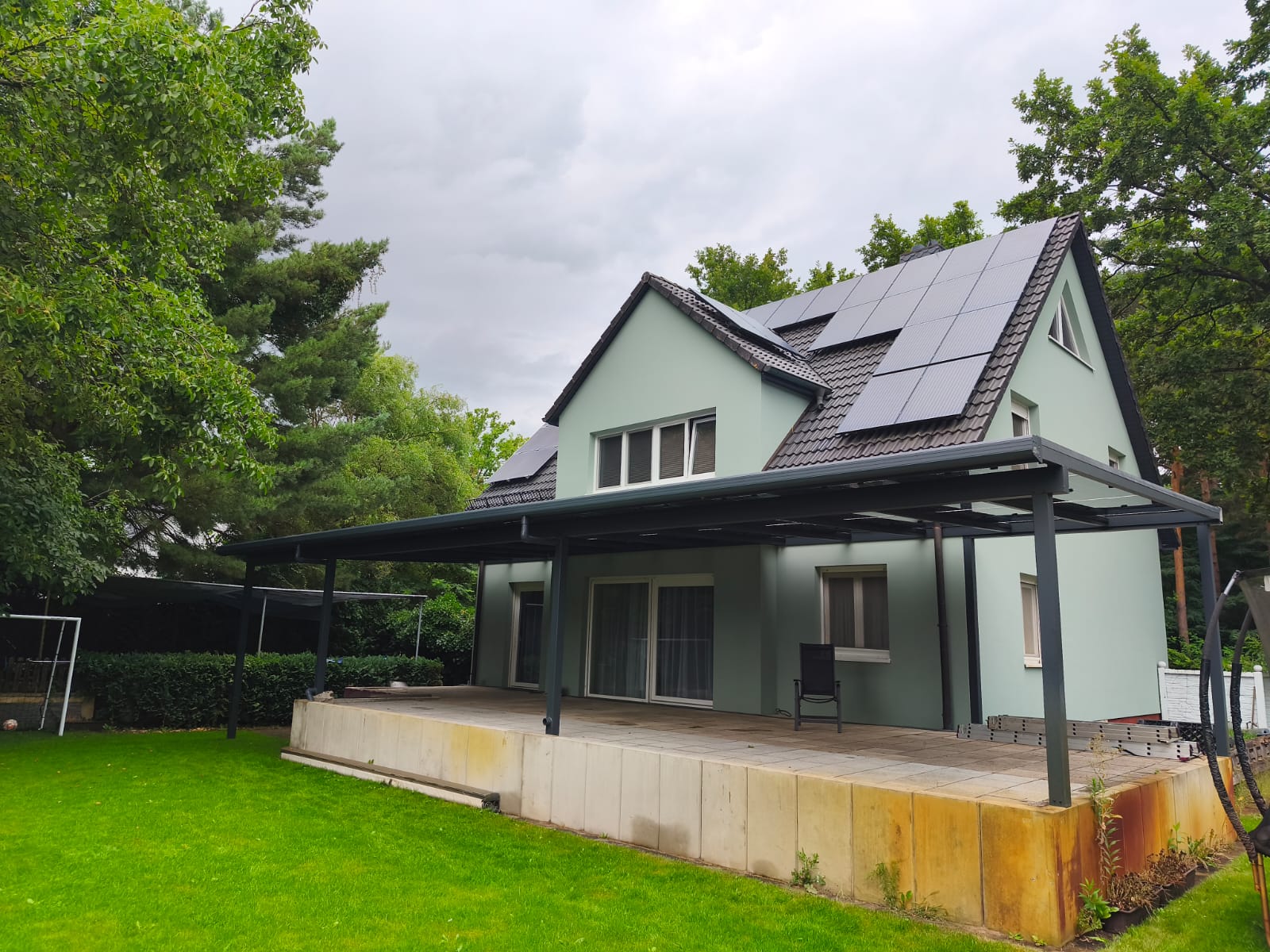 Gesamtansicht des Einfamilienhauses mit Solar-Terrassendach und Photovoltaikanlage auf dem Satteldach